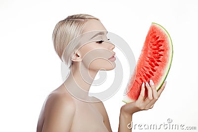Watermelon in hands of women, clean smooth skin of body and face. Blonde girl in summer holding a watermelon in hands of face. Stock Photo