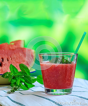 Watermelon juice glass closeup view, blur green nature background Stock Photo