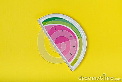 Watermelon-like plate on yellow background Stock Photo