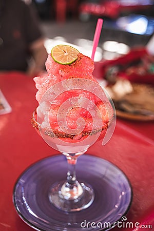 Watermelon margarita, with a piece of lemon crowning it, with the edge of the glass with chili powder Stock Photo