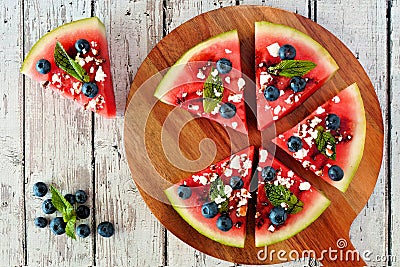 Watermelon pizza with blueberries, feta and mint on serving board Stock Photo