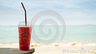Watermelon Red Smoothie in Glass on Blur Blue Sea and Blue Sky Background Stock Photo
