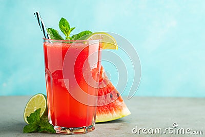 Watermelon slushie with lime and mint, summer refreshing drink in tall glasses on a light blue background. Sweet cold Stock Photo