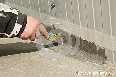 Waterproofing an outside wall-floor connection with ms polymer sealant Stock Photo