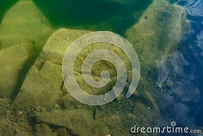 The waters of the basalt lake, the stones in the lake are covered with algae, clear and pure water Stock Photo