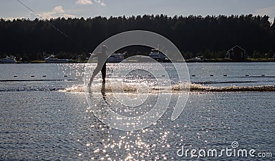 Waterskier silhouette moving fast in splashes of water at sunset Stock Photo