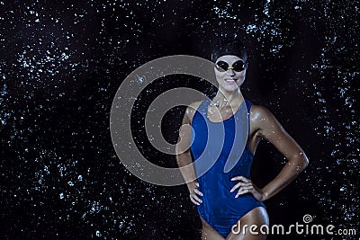 Watersports Concepts. Sensual Sportive Caucasian Female Swimmer in Swimsuit Posing in Goggles in Aqua Studio With Multiple Water Stock Photo