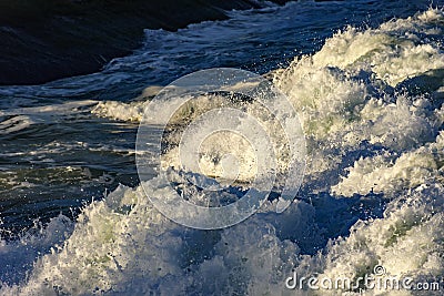 Wave foam advancing on the rocks Stock Photo