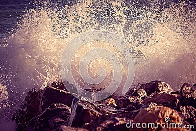 Wave hit the rock at the beach, sea water splash spray up at sunset Stock Photo