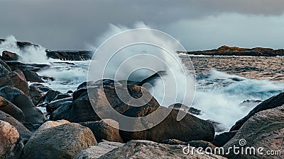 Wave hiting rocks at sunset Stock Photo