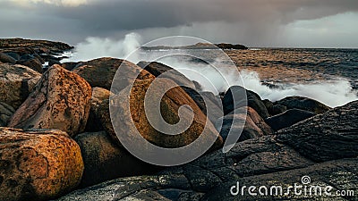 Wave hiting rocks at sunset Stock Photo