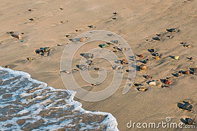 Wave hits beach with colorful pebble stones - closeup Stock Photo