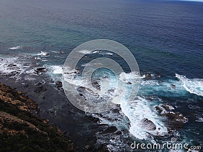 waves beat against rocks Stock Photo