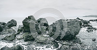 Waves beating on beach. Rocky sea shore. Monochrome image Stock Photo