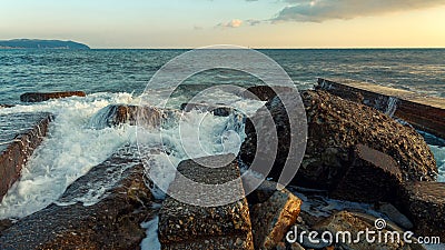 Waves break on coastal stones Stock Photo