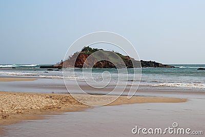 Waves breaking on the hill in the middle of the sandy beach Stock Photo