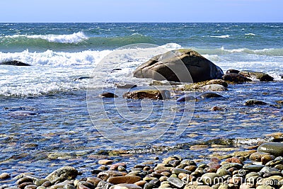 Waves crashing against rock filled beach at The Arches Stock Photo