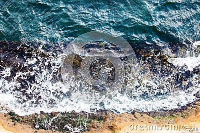 Waves crashing breaking on the rocks. Drone aerial sea surface view Stock Photo