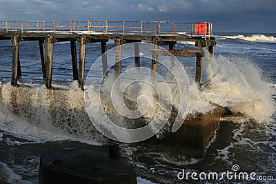 Waves crashing into pier Stock Photo