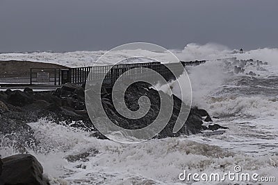 waves hitting against the pier during storm in Nr. Vorupoer on the North Sea coast Stock Photo