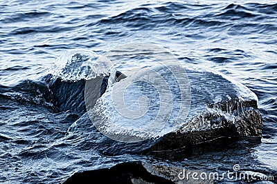 Ice frozen over rocks in lake shore Stock Photo