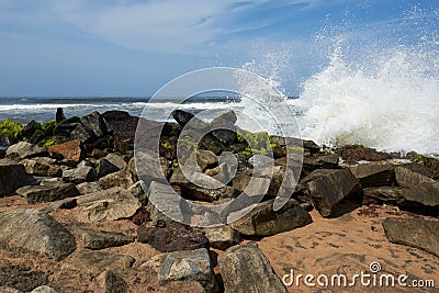 Waves pounding rocks on a beach Stock Photo