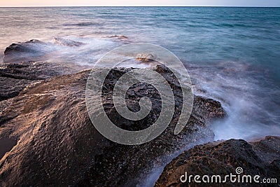 Waves and rocks shore long exposure Stock Photo