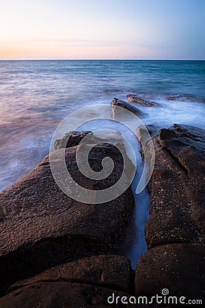 Waves and rocks shore long exposure Stock Photo