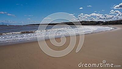 Waves rolling up the smooth sandy beach of the bay, Sea Palling, Norfolk, UK Stock Photo