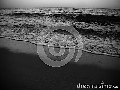 Waves and the sea shore in the evening. Monochrome photo. Stock Photo