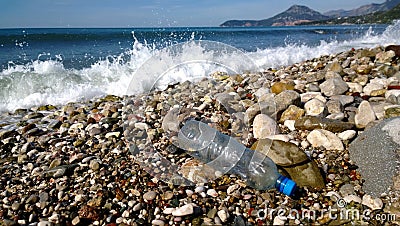 The waves of the sea washed up an empty plastic bottle. Environmental pollution - garbage in scenic spots Stock Photo