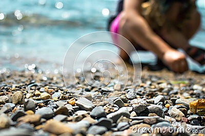 Waves washing over gravel beach and playing kid Stock Photo