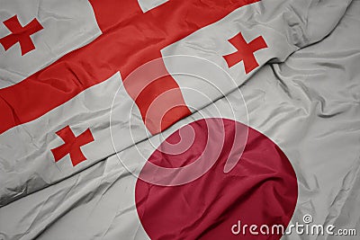 waving colorful flag of japan and national flag of georgia Stock Photo