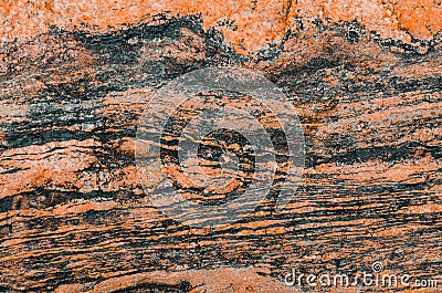 Wavy texture of granite stone red tint and dark stripes. Stock Photo