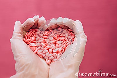 Wax for depilation of pink color in the form of a heart. The concept of depilation, waxing, smooth skin. Copy space Stock Photo