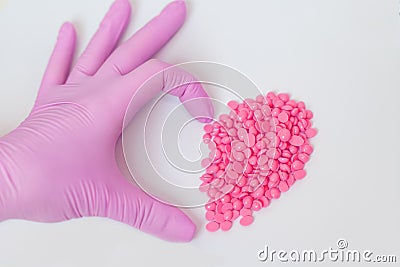 Wax for depilation of pink color. in the form of a heart. On white background. The concept of waxing, smooth skin Stock Photo