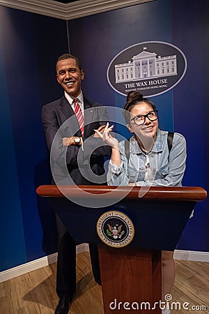 In the wax house, President Barrack Obama witha young girl posing as secretary, smile indoors wax museum Editorial Stock Photo