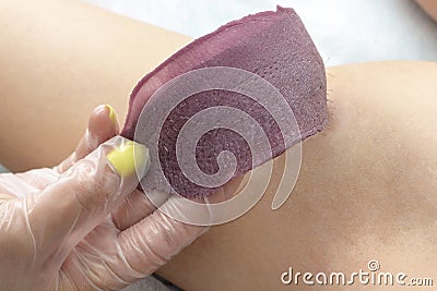 Waxing cosmetic depilation procedure removing wax from skin Stock Photo