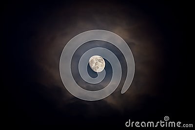 Waxing moon encircled by clouds Stock Photo