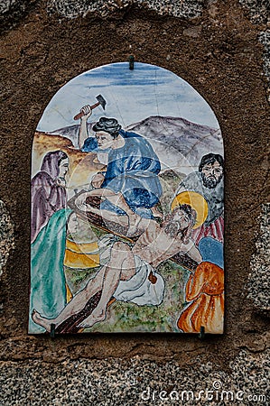 Way of the cross. 11th Station. Jesus is nailed to the cross. Hand painted ceramic tile, Ingurtosu, Arbus, South Sardinia Editorial Stock Photo