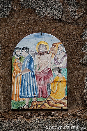 Way of the cross. 10th Station. Jesus is stripped of his clothes. Hand painted ceramic tile, Ingurtosu, Arbus, South Sardinia Editorial Stock Photo