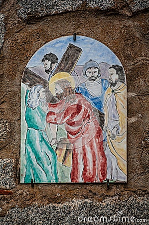 Way of the cross. 5th Station. Simon of Cyrene helps Jesus to carry the cross. Painted ceramic tile, Ingurtosu, Arbus, Sardinia Editorial Stock Photo