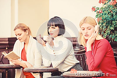 Way to relax and recharge. Female leisure. Group pretty women terrace entertain themselves with reading and listening Stock Photo