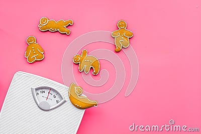 Ways for lose weight. Sport. Cookies in shape of yoga asans near scale on pink background top view copy space Stock Photo