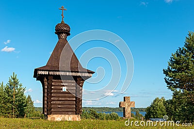 A small chapel and an old cross on a hilltop Stock Photo