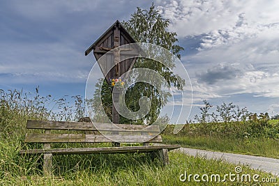 Wayside cross and wooden bench in the Bavarian forest in GrÃ¼b with Grafenau Stock Photo