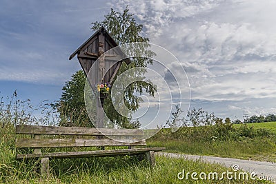 Wayside cross and wooden bench in the Bavarian forest in GrÃ¼b by Grafenau Stock Photo
