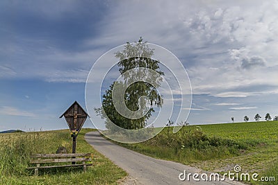 Wayside cross and wooden bench in the Bavarian forest in GrÃ¼b by Grafenau Stock Photo