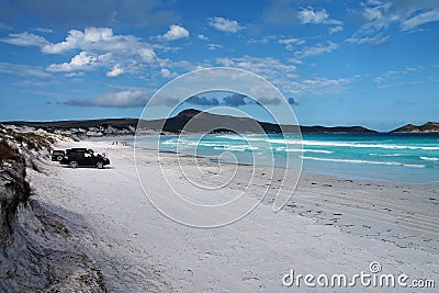 4WD cars parked on white sandy beach at Lucky Bay, Western Australia Stock Photo