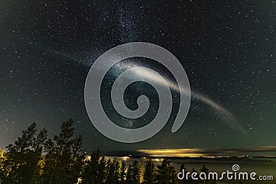 Weak Northern Lights on horizon and atmospheric phenomenon `STEVE` crossing Milky Way. Steve appears as a purple and green light Stock Photo